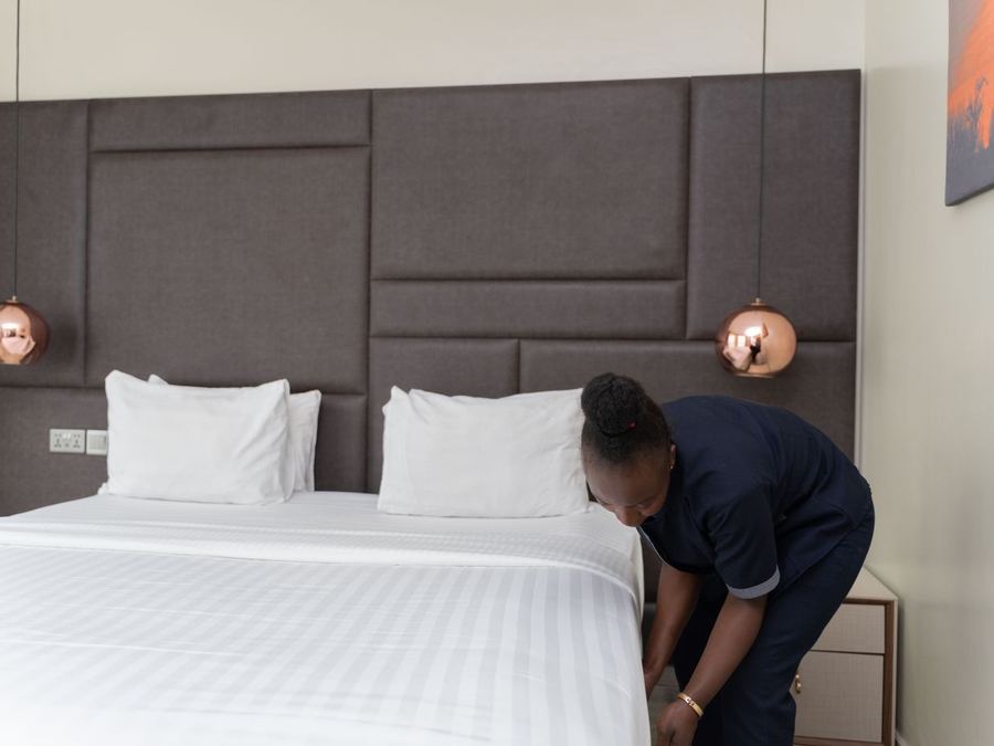 Hotel room attendant making a bed