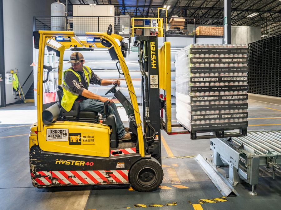 Forklift operator moving goods in a warehouse