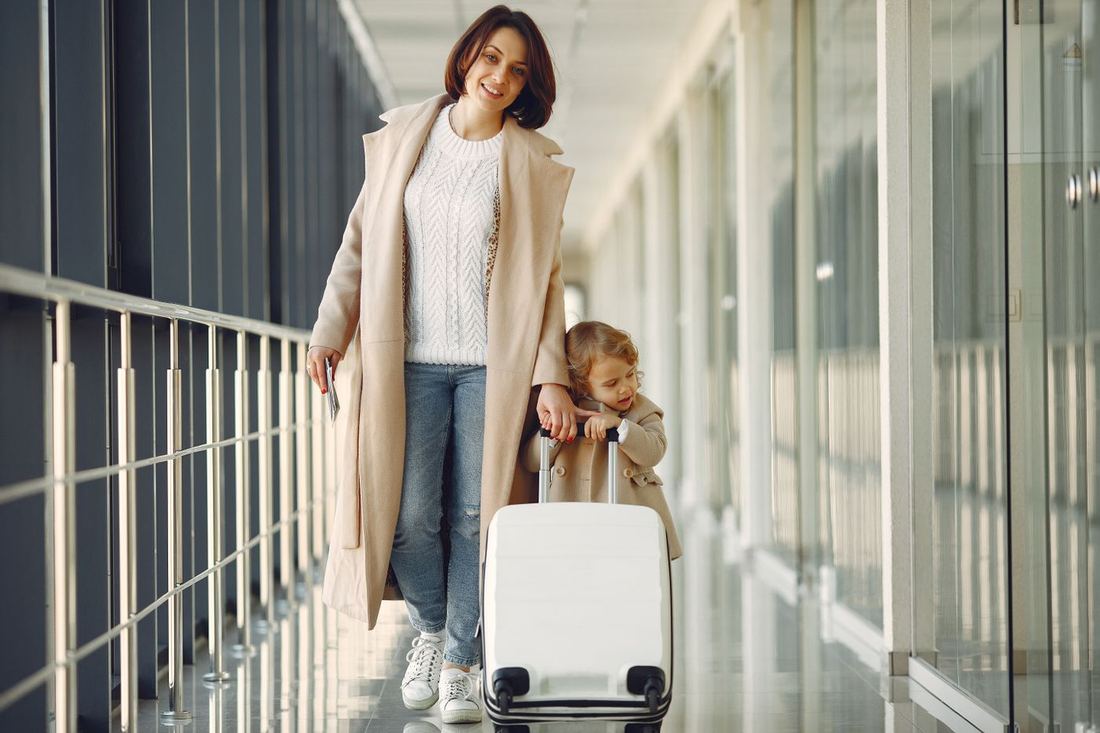 Mother and child with a suitcase at an airport